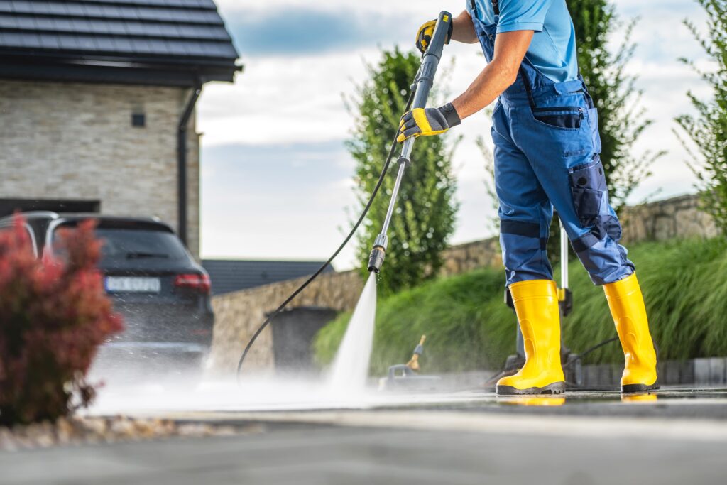 caucasian-homeowner-using-powerful-pressure-washer-clean-dirty-driveway-min